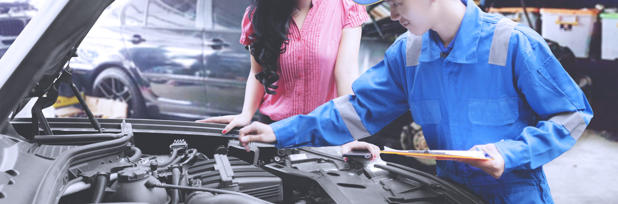 Mechanic helping a customer fixing a car in a repair shop