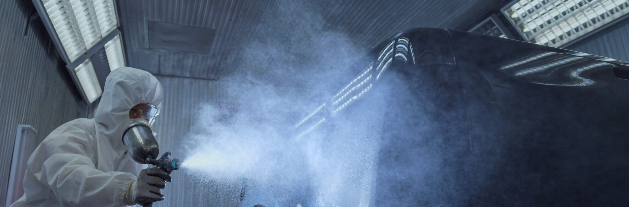 close up of paint spray gun, worker painting a car